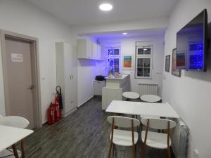 a kitchen with white tables and chairs in a room at Red House in Kyustendil