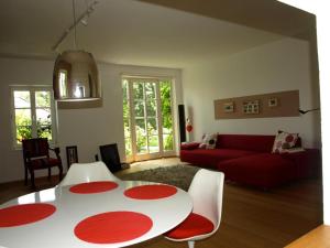 a living room with a red couch and a white table at Ferienwohnung Dausacker in Utting