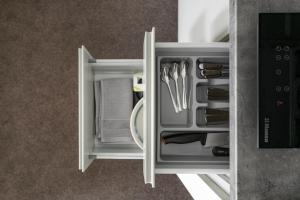 an open drawer with utensils in a refrigerator at Senamiesčio apartamentai in Tauragė