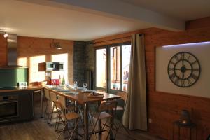 a kitchen with a table and a clock on the wall at Carene - Belle plagne - 8 personnes in Belle Plagne