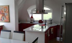 キュステンディルにあるApartment Sagittariusのキッチン(赤いキャビネット、白いカウンタートップ付)