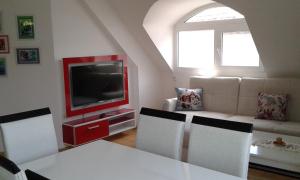 uma sala de estar com uma mesa e uma televisão em Apartment Sagittarius em Kyustendil
