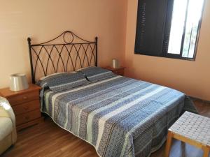 a bedroom with a bed with a blue and white blanket at Donde Brilla el Sol in Candelaria