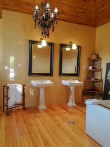 un bagno con due lavandini e un lampadario a braccio di Casa de Quintã a Marco de Canaveses
