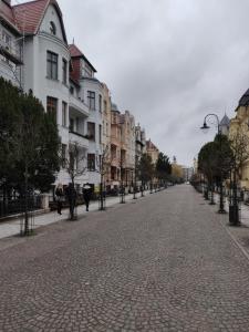 une rue pavée dans une ville avec des bâtiments dans l'établissement Apartament Helena, à Świnoujście