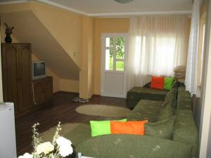 a living room with a green couch with colorful pillows at Apartmani Simonovic in Soko Banja
