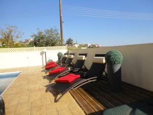 - une rangée de chaises assises sur une terrasse dans l'établissement Villa Swalletta, à Larnaka