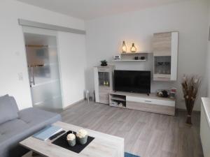 a living room with a couch and a flat screen tv at Kaiserpfalzquartier in Goslar