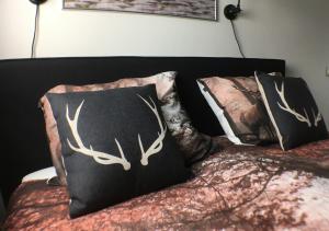 ein Bett mit zwei Kissen und Hirschgeweihen darauf in der Unterkunft Velo-Droom in Otterlo