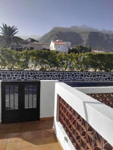 a black door on a white building with mountains in the background at Donde Brilla el Sol in Candelaria