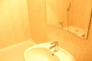 W łazience znajduje się umywalka, lustro i wanna. w obiekcie Yasmine Flat w Budapeszcie