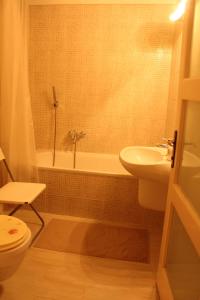 a bathroom with a sink and a tub and a toilet at Yasmine Flat in Budapest