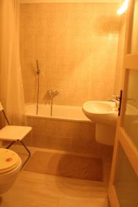 łazienka z umywalką, wanną i toaletą w obiekcie Yasmine Flat w Budapeszcie