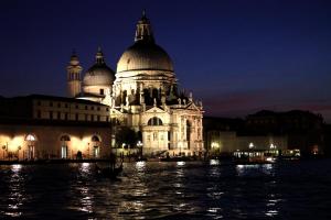 un edificio di notte con acqua di fronte di Venice Apartments San Marco a Venezia