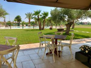 a patio with a table and chairs and a park at Agriturismo San Gallo in Strassoldo