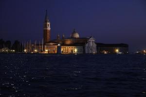 un grande edificio con torre dell'orologio di notte di Venice Apartments San Marco a Venezia