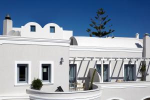 a white house with a christmas tree on the roof at Pnoi Luxury Suites in Karterados
