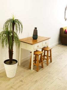 a wooden desk with a plant and two stools at Lisbon City Studio Apartment in Lisbon