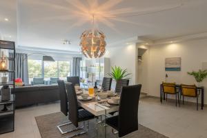 a dining room and living room with a table and chairs at VERASOL 3 in Albufeira