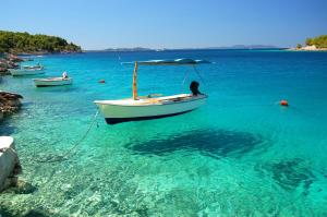 a boat in a body of water with other boats at ECO Aparthotel The Dreamers's Club in Lumbarda