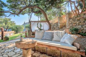 a couch sitting on a stone wall with a table at ECO Aparthotel The Dreamers's Club in Lumbarda
