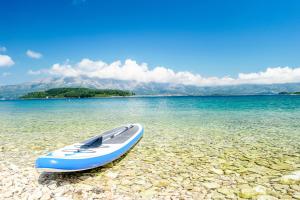 a blue kayak sitting on a beach in the water at ECO Aparthotel The Dreamers's Club in Lumbarda