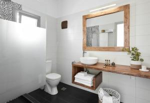 a bathroom with a sink and a mirror at Pnoi Luxury Suites in Karterados