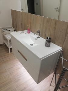 een badkamer met een witte wastafel en een spiegel bij B&B San Vito in Gravina in Puglia +5 foto's