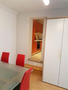 a dining room with a table and red chairs at Zeuthen Ferienwohnung am See, Stadtgrenze Berlin in Zeuthen