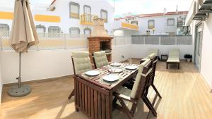 una sala da pranzo con tavolo e camino di Apartamento Praia de Altura com Terraço, Barbecue, A/C e Wifi ad Altura