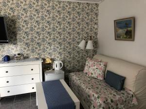 1 dormitorio con sofá, vestidor y cama en Stakaberg Konferens & Gårdshotell, en Halmstad