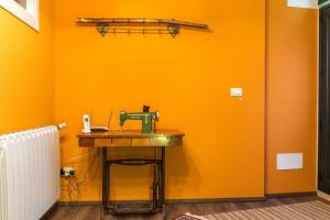 a yellow room with a sink with a sewing machine on it at Casa La Scala in Linguaglossa