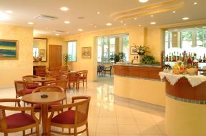 a restaurant with tables and chairs and a bar at Hotel De La Plage in Rimini