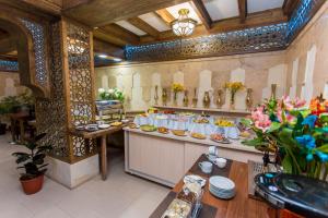 a restaurant with a buffet of food in a room at Kukaldosh Boutique Hotel in Bukhara