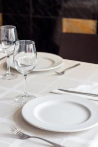 a table with white plates and wine glasses on it at Hostal San Miguel in Ponferrada