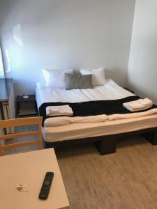 a bed in a room with a table and a remote control at REK Inn in Reykjavík