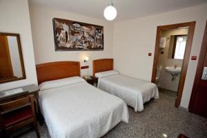 Habitación de hotel con 2 camas y lavamanos en Hostal San Miguel, en Ponferrada