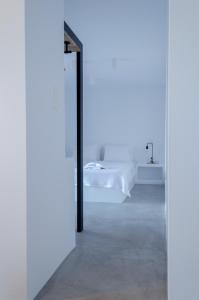 a white room with a mirror and a bed at L’arco Milos Suite in Adamas