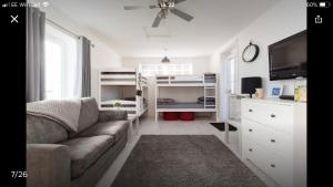 ein Wohnzimmer mit einem Sofa und Etagenbetten in der Unterkunft The Shed in Merthyr Tydfil