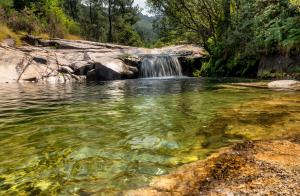 una cascada en medio de un río en Apartamentos El Valle, en Bubaces