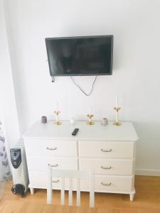 a white dresser with a flat screen tv on a wall at Resitur Luxury Suit 2 in Seville