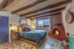 una camera da letto con un letto e un camino di Adobe and Pines Inn Bed and Breakfast a Taos
