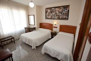 a hotel room with two beds and a window at San Miguel in Ponferrada