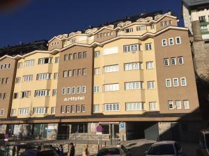apartamentowiec z samochodami zaparkowanymi przed nim w obiekcie Loft con WiFi y Parking en el corazón de Sierranevada w mieście Sierra Nevada