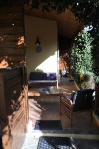 un patio avec deux bancs et une horloge sur le mur dans l'établissement Patrimonio chambre avec commodités chez l’habitant, à Patrimonio