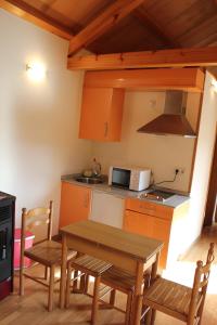 Una cocina con mesa y sillas y un microondas. en As Casas das Minas, en Zobra 34 fotos más