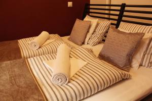 łóżko z ręcznikami i poduszkami w obiekcie Yasmine Flat w Budapeszcie