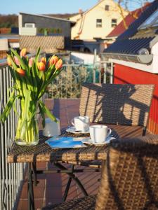 einen Tisch mit einer Blumenvase auf dem Balkon in der Unterkunft Ferienwohnungen Wergin in Ostseebad Koserow