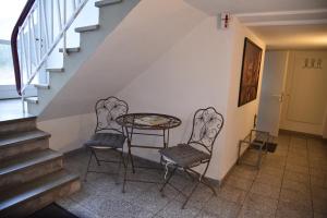 a table and two chairs in a hallway with stairs at Apartment Aurachtal Oberreichenbach in Oberreichenbach