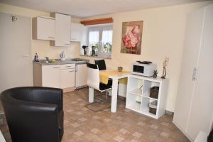 een keuken met een tafel en stoelen en een magnetron bij Apartment Aurachtal Oberreichenbach in Oberreichenbach